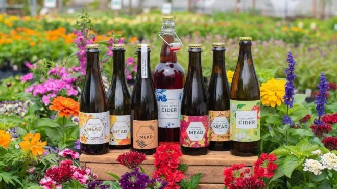 a selection of ciders and meads by Heeman's, resting in a flower bed