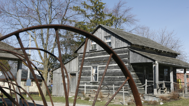 Wagon wheel and log house