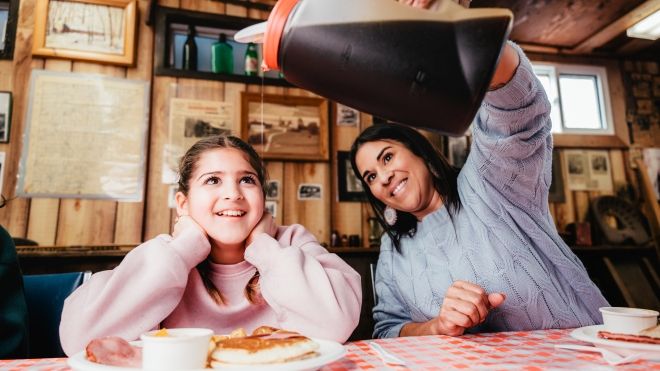 Mother pouring maple syrup for her daughter