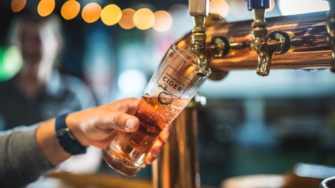 Tap pouring cider into a glass