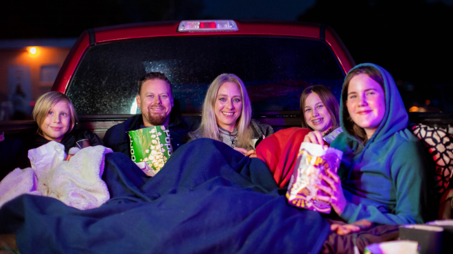 Family watching a movie at a drive in theatre