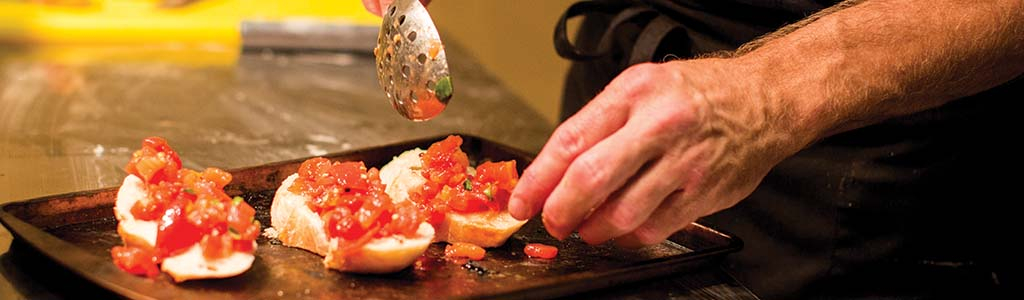 man preparing bruschetta