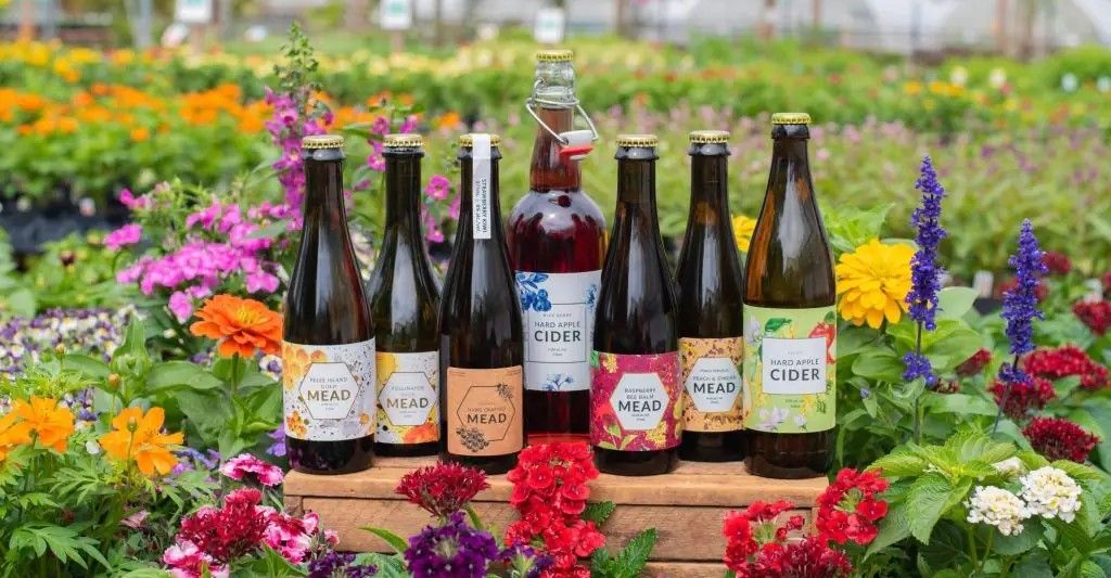 a selection of ciders and meads by Heeman's, resting in a flower bed