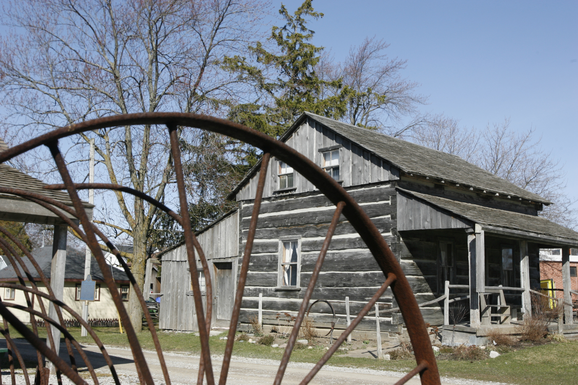 Wagon wheel and log house