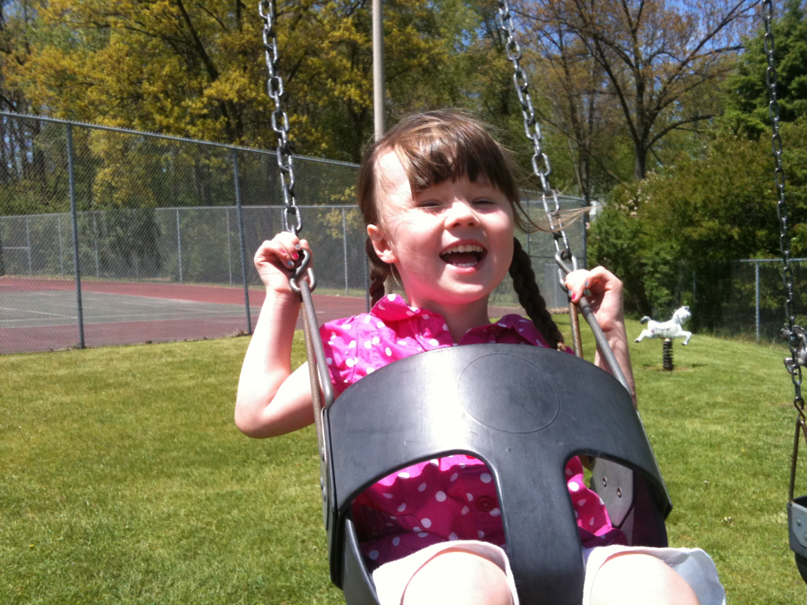 girl playing on a swing 