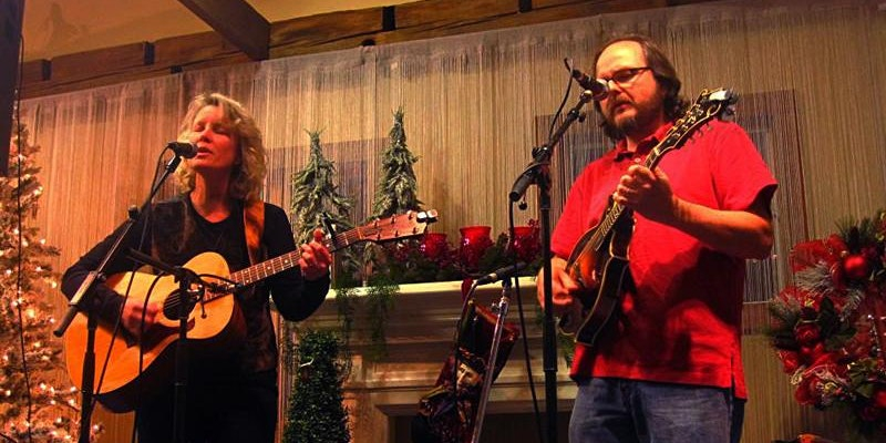 Man and woman playing guitar and singing 