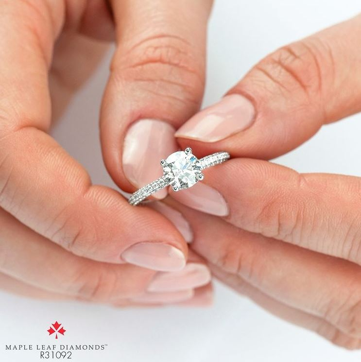 two hands holding a diamond ring 